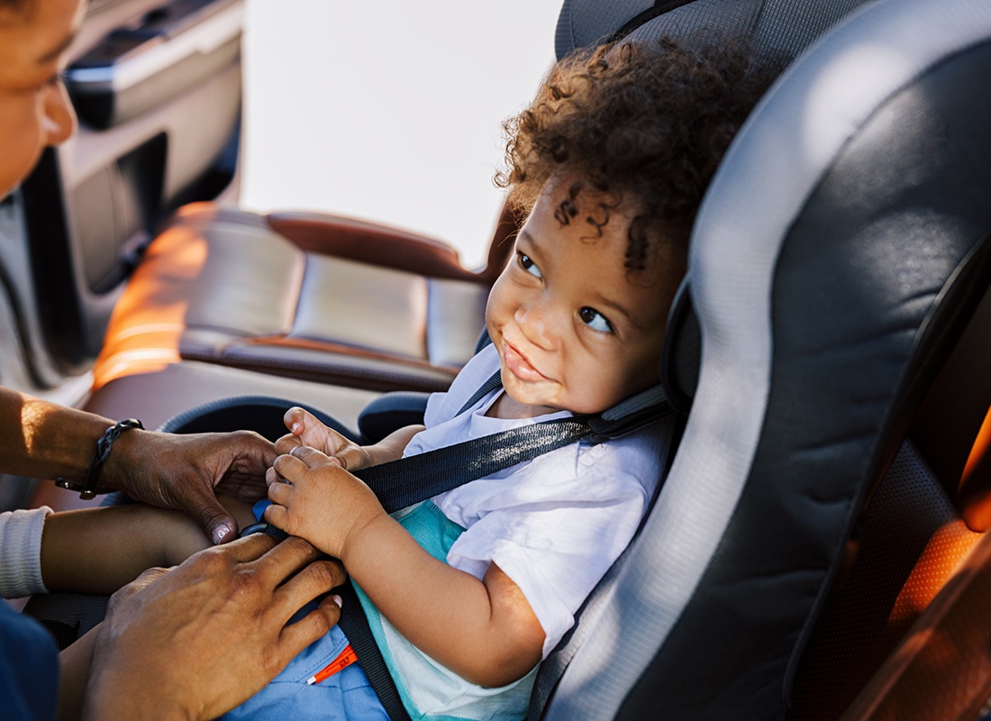 Personal Insurance - Mother Taking a Baby Out of a Carseat
